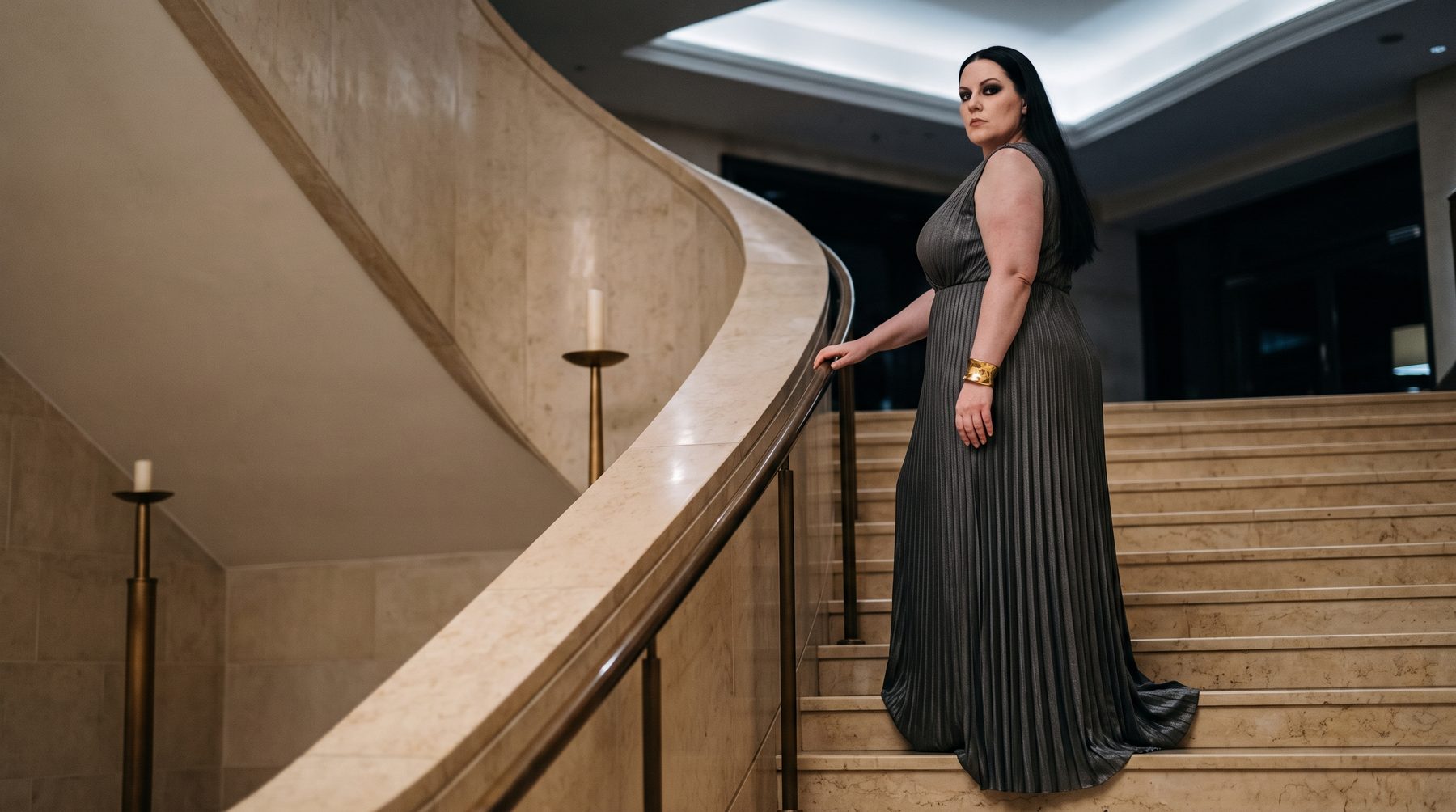Grey pleated evening gown on a staircase